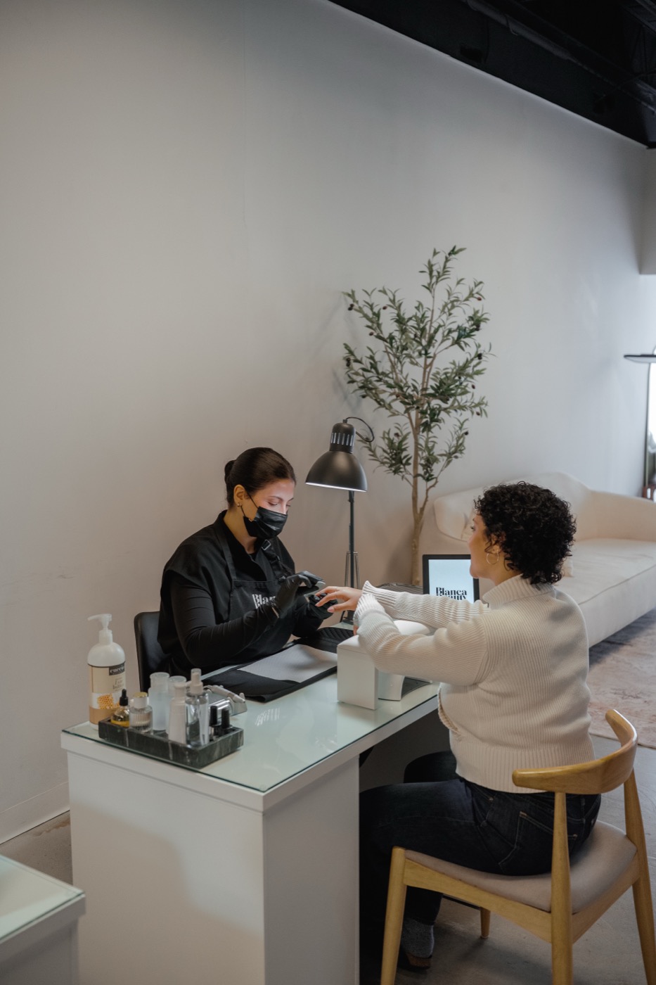 Inside Blanca Beauty Bar, a specialist working with a client in soft daylight