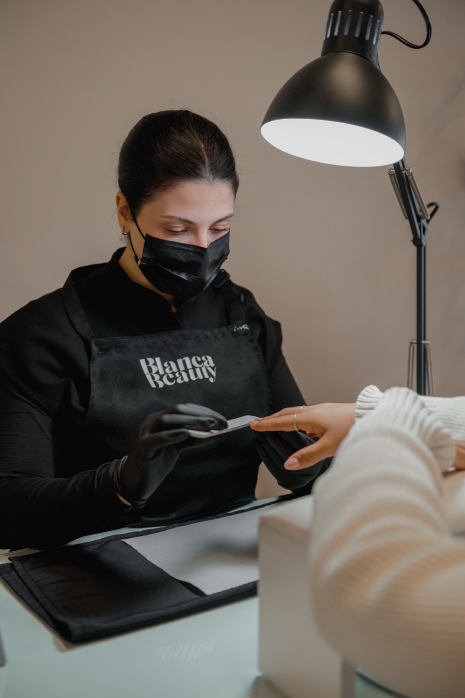 A Blanca Beauty Bar specialist at the station, looking toward the camera in soft studio daylight